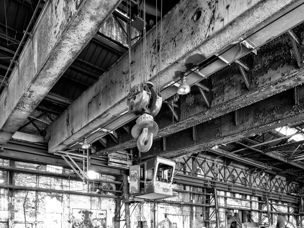 Black and white medium format photograph of a hook hanging from massive steel beams inside Chattanooga's vast abandoned Wheland Foundry, last occupied in 2003