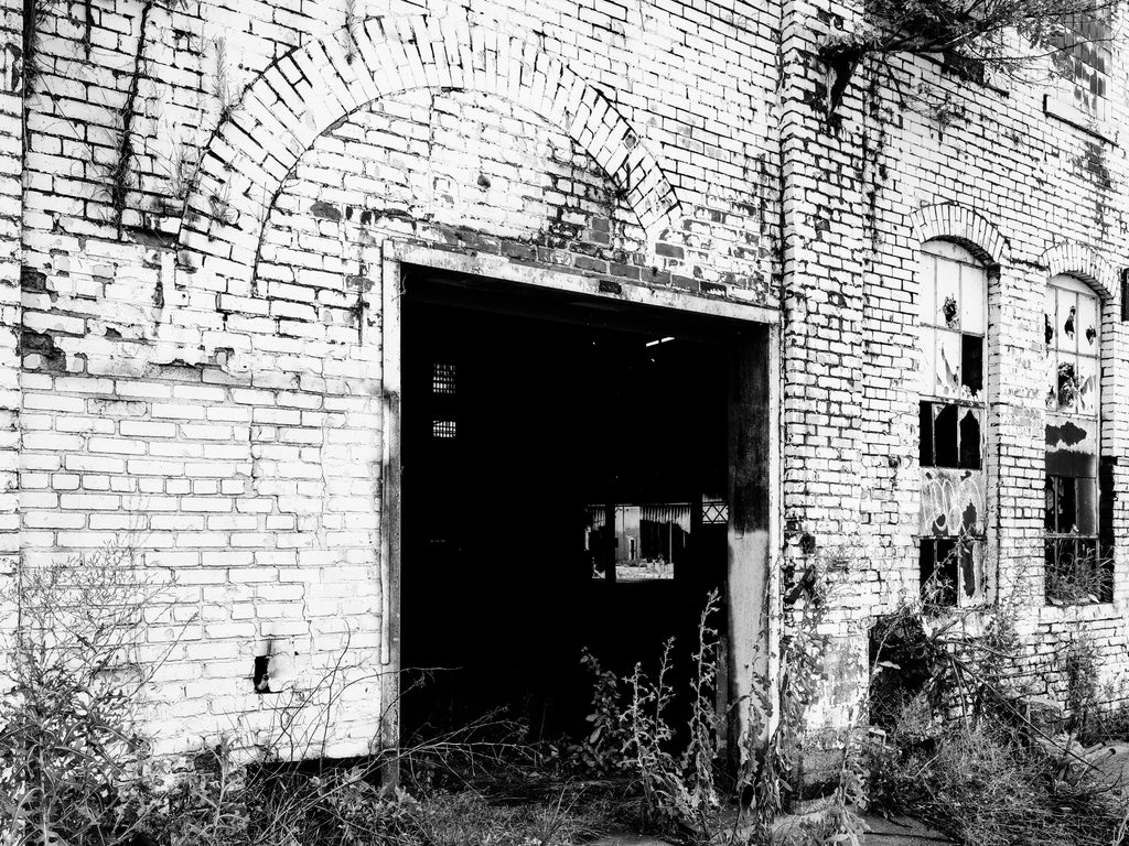 Black and white medium format photograph through an open doorway into Chattanooga's vast, abandoned Wheland Foundry, which closed forever in 2003.