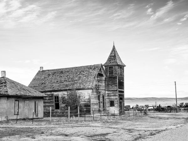 Black and white photograph of an abandoned wooden church in the isolated prairie ghost town at Cottonwood, South Dakota.