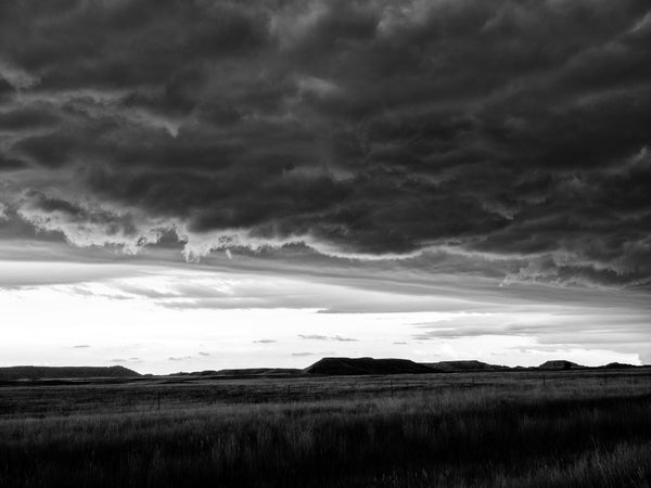 Black and white photograph of dark, stormy skies over the Black Hills of South Dakota.