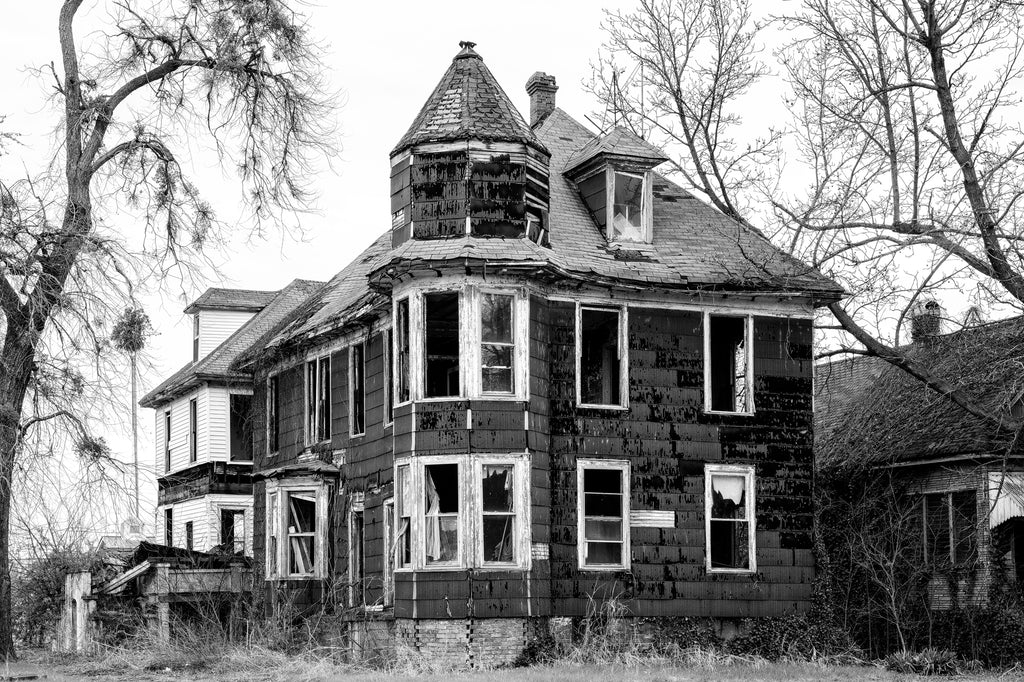 Black and white photograph of a historic abandoned house that formerly stood along Washington Avenue in Cairo, Illinois, but has since been demolished.
