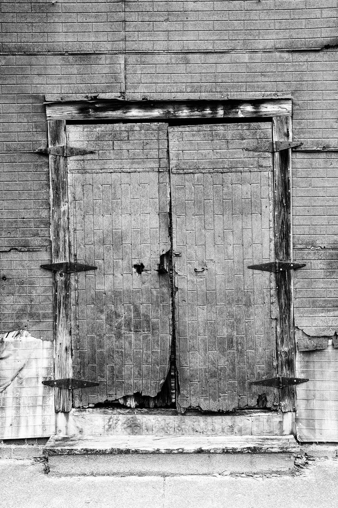 Black and white photograph of the rusty old doors of a former cotton warehouse in the small community of Newbern, Alabama. This building was previously photographed by the legendary photographer William Christenberry.