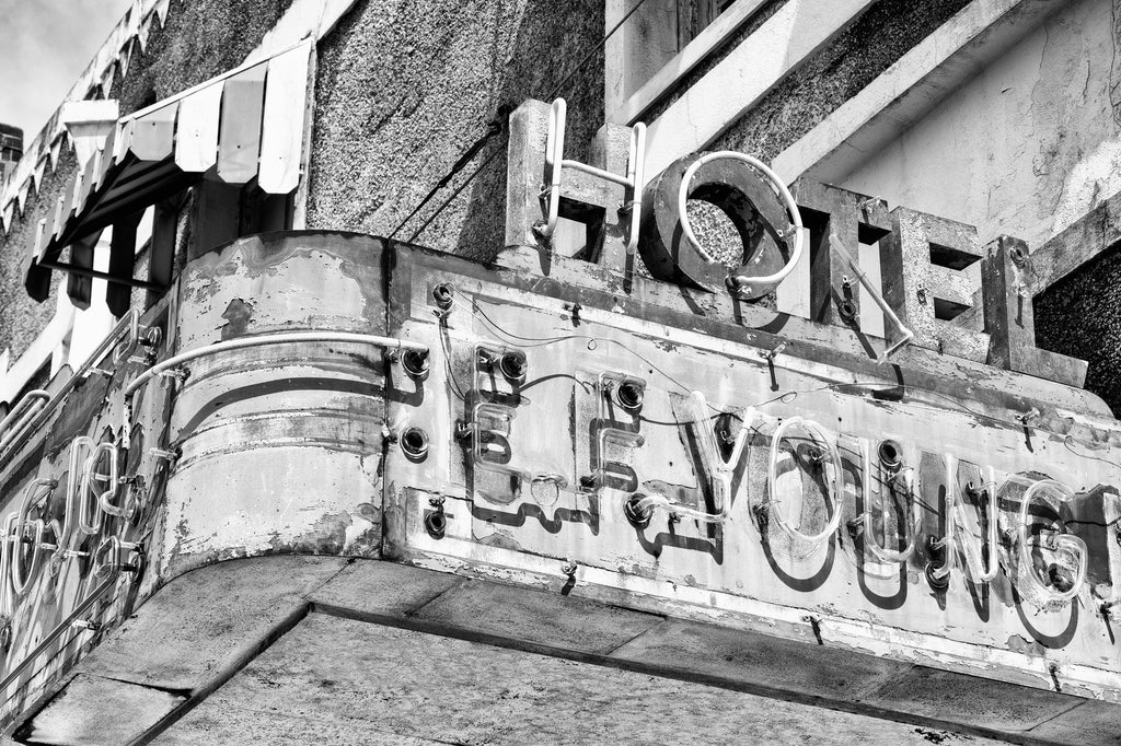 Black and white photograph of the old neon marquee sign for the abandoned E.F. Young Jr. Hotel in Meridian, Mississippi. Part of Meridian's Black business district, the E.F. Young Jr. Hotel was a Green Book listed hotel built in 1946. Long abandoned, it was demolished in April 2023.