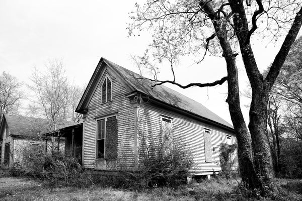 Black and white photograph of a beautiful old house now abandoned in a mostly abandoned neighborhood in Meridian, Mississippi