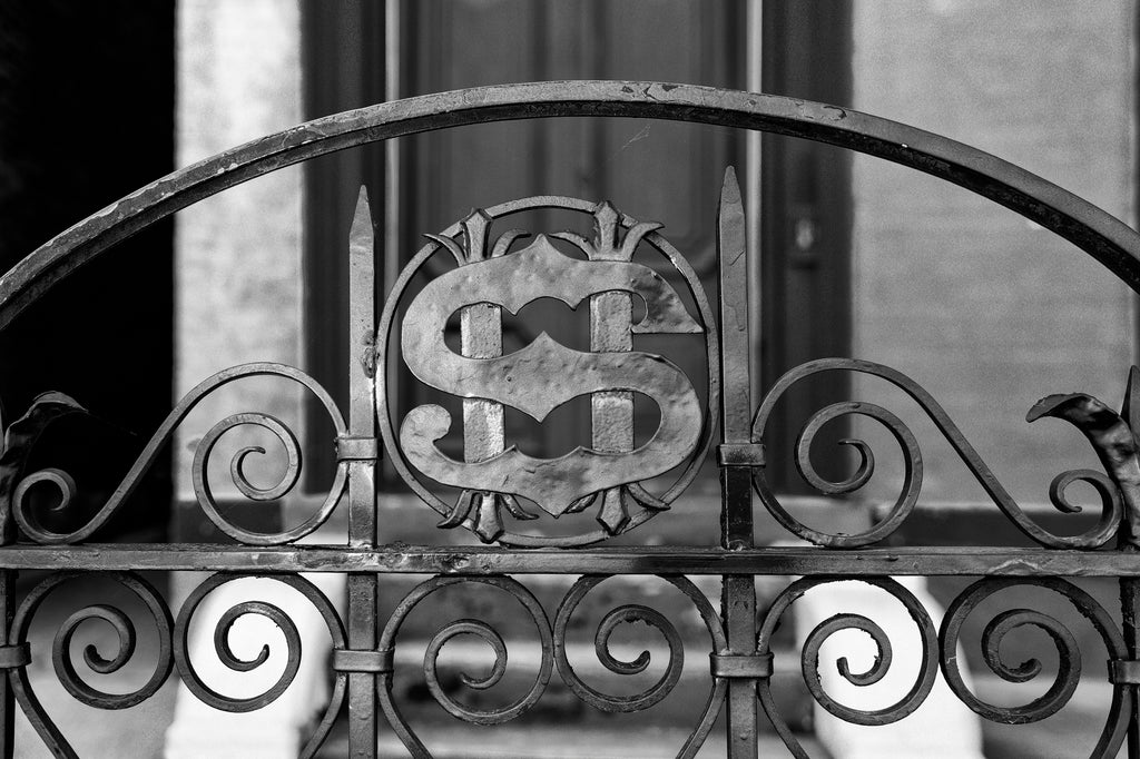 Black and white photograph of the letter S that looks like a dollar sign on the front gate of the Victorian Mansion that once belonged to millionaire businessman Henry Schmulbach in Wheeling, West Virginia.