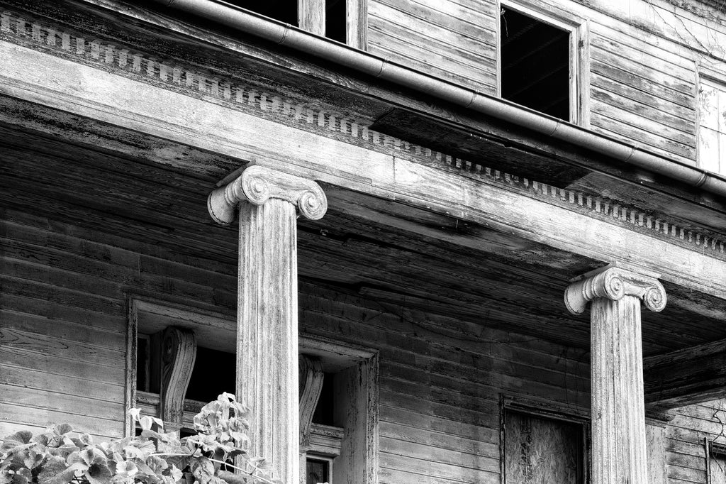 Black and white photograph of the front of the historic abandoned Judge Mark Bird House which stands behind the Post Office in Woodstock, Virginia. The 1840 mansion also once housed the Woodstock Female Seminary.