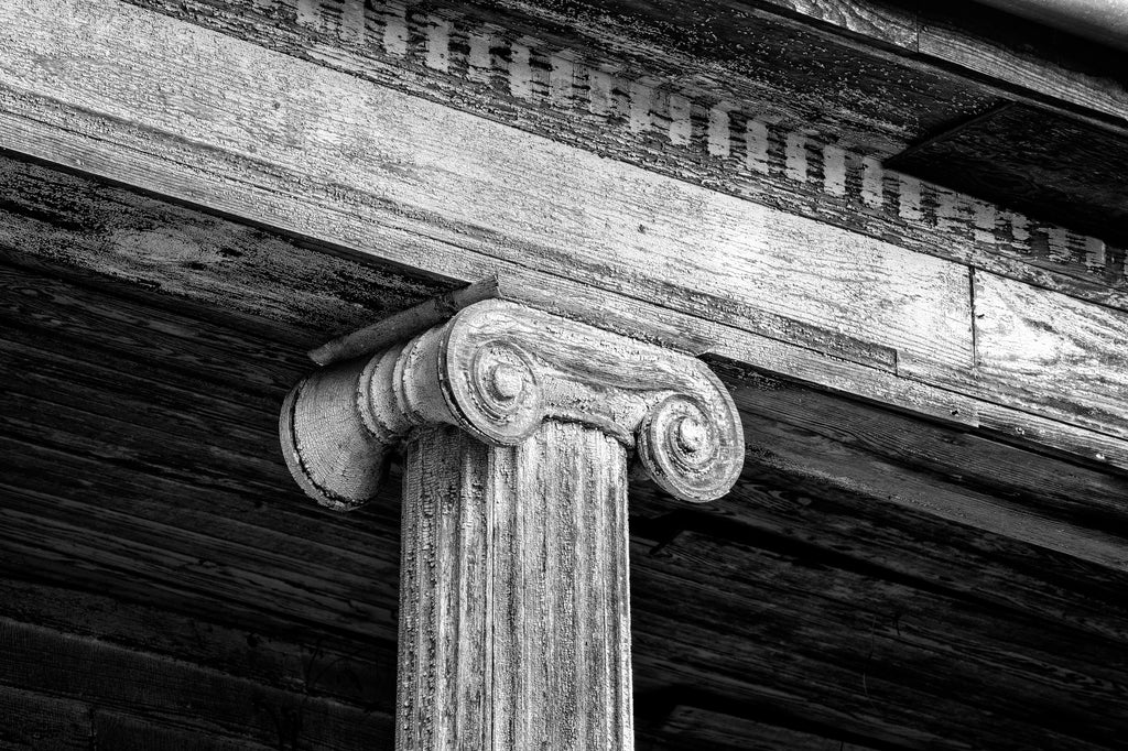 Black and white photograph of cracked paint patterns on a heavily weathered wooden column on the historic abandoned Judge Mark Bird House built circa 1840 in Woodstock, Virginia.