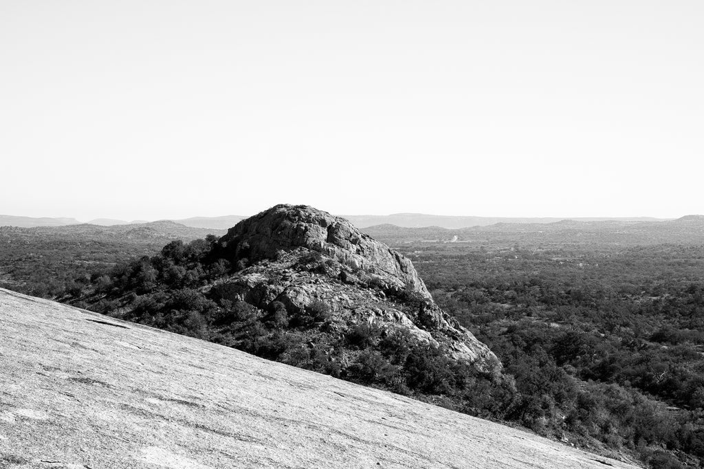 Black and white landscape photograph of the rugged Turkey Peak as seen from the sloping side of Enchanted Rock near Fredericksburg, Texas.