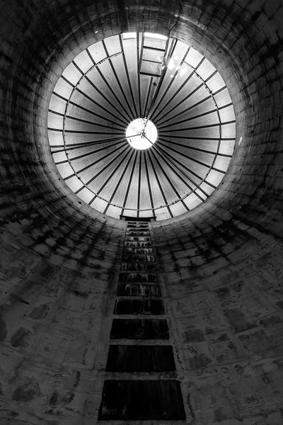 Black and white photograph looking up at the interior top of a grain silo on a former dairy farm.