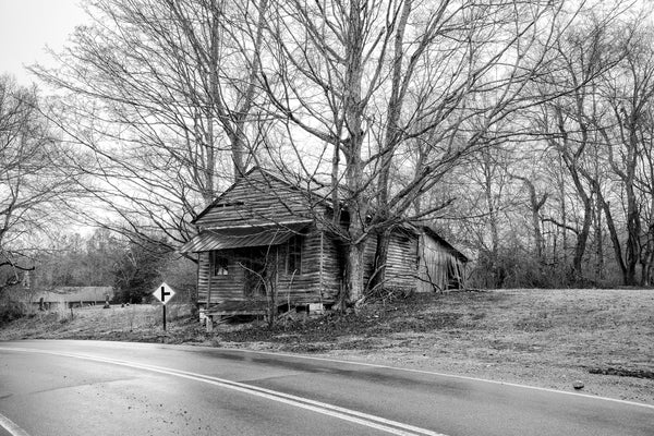 Black and white photograph of a historic old wooden country store next to a cemetery on a rainy backroad not far from Lynchburg, Tennessee.