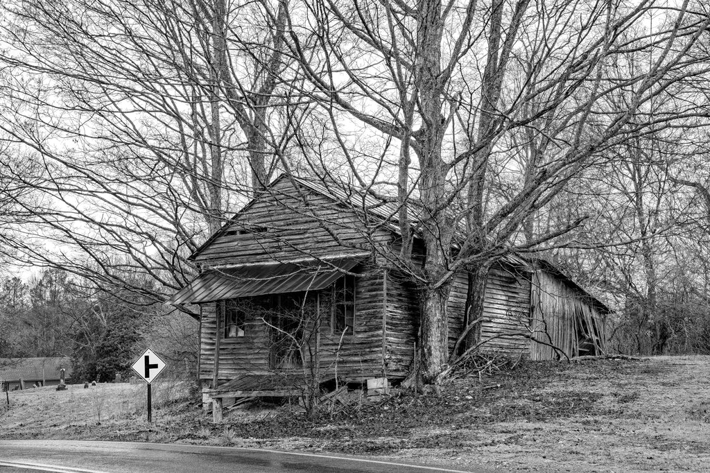 Black and white photograph of a historic old wooden country store next to a cemetery on a rainy backroad not far from Lynchburg, Tennessee.