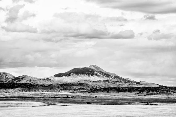 Black and white landscape photograph of a mountain seen across a broad rolling valley in Montana.