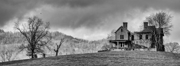Dramatic black and white wide-format photograph of the ruins of an abandoned historic home perched on a hilltop in Western Virginia.