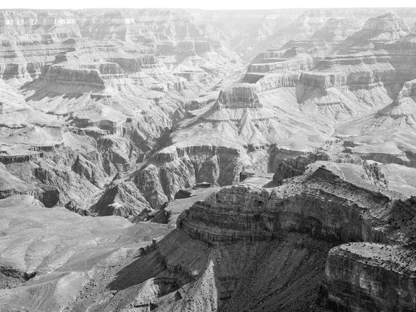 Black and white medium format photograph of Arizona's vast and rugged Grand Canyon landscape with its depths emphasized by a thin layer of morning haze.