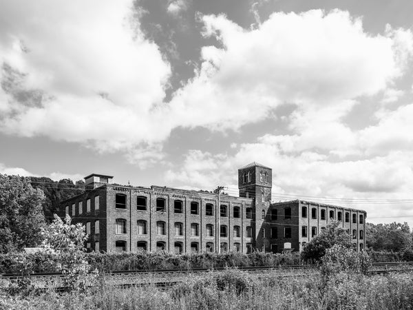 Black and white medium format photograph of the old Gilbert Knitting Mill along the Erie Canal in Little Falls, New York. The mill operated from the 1880s until the 1960s.