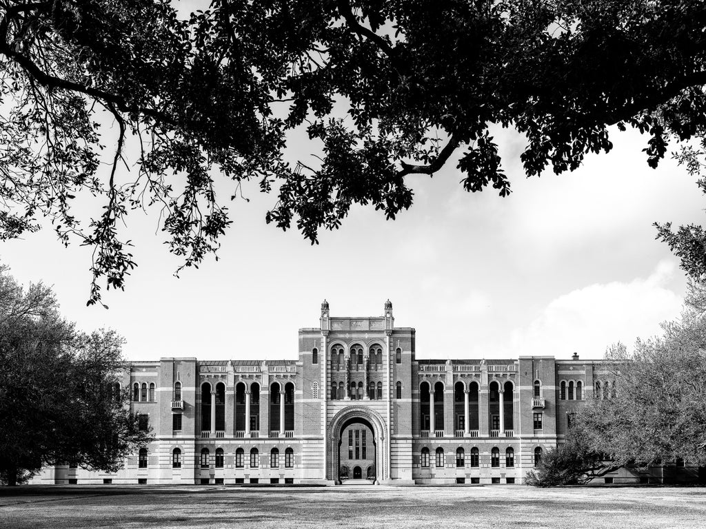 Black and white photograph of the distinctive architecture of Lovett Hall seen from across its wide lawn on the campus of Rice University in Houston, Texas.