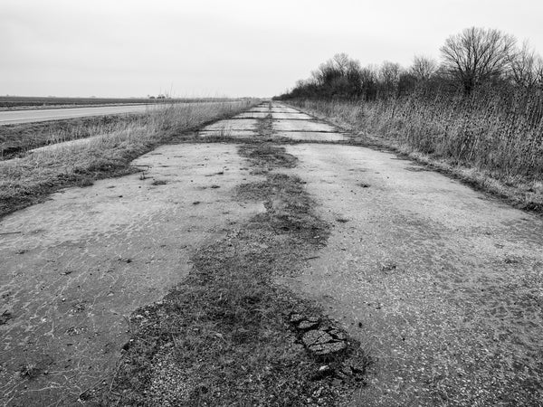 Black and white photograph of a closed section of old Route 66 in Illinois between Mount Olive and Litchfield.