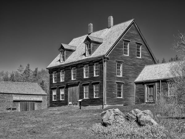 Black and white photograph of the Olson House in rural Cushing, Maine, made famous by artist Andrew Wyeth's 1948 painting Christina's World. Built in the late 1700s by a sea captain, the house is now owned by the Farnsworth Museum.