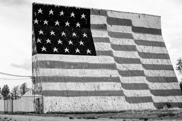 Black and white fine art photograph of a huge, hand-painted American flag across the outside of a drive-in movie theater in the Texas Panhandle.