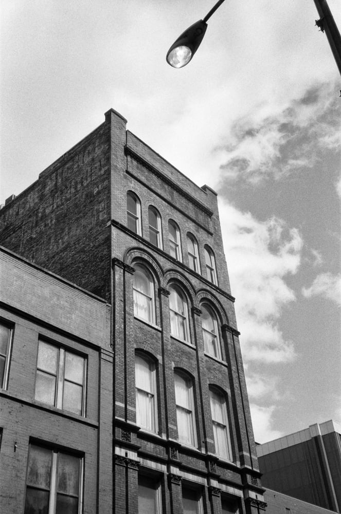 Black and white photograph of a historic circa 1900 Nashville office building with a faded ghost sign for the long-gone Bradford Nichol Furniture, which was open for business by at least 1870 at 25 and 27 North College Street in Nashville, according to a listing in The Masonic Record, published that year.