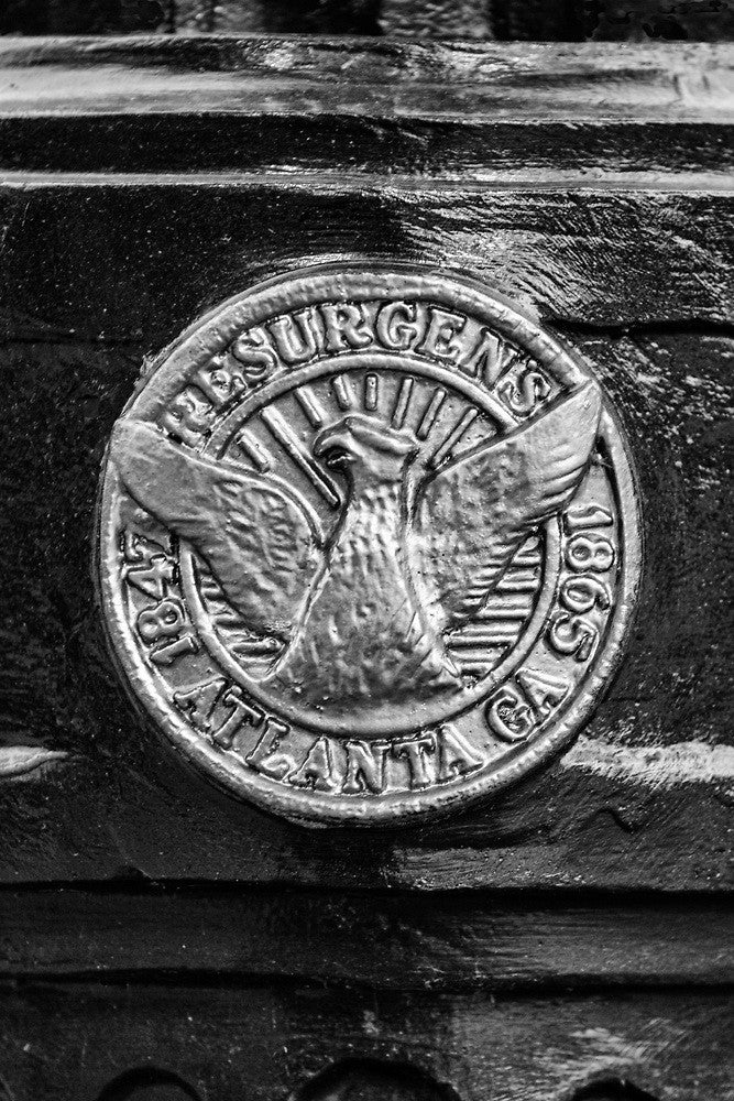 Black and white photograph of Atlanta's Resurgens logo as seen on a light post. Resurgens roughly translates to "rise again," remembering when Atlanta had to rebuild from the ashes of the Civil War.