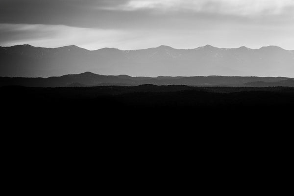 Black and white fine art landscape photograph of hazy Colorado mountains in early morning light.