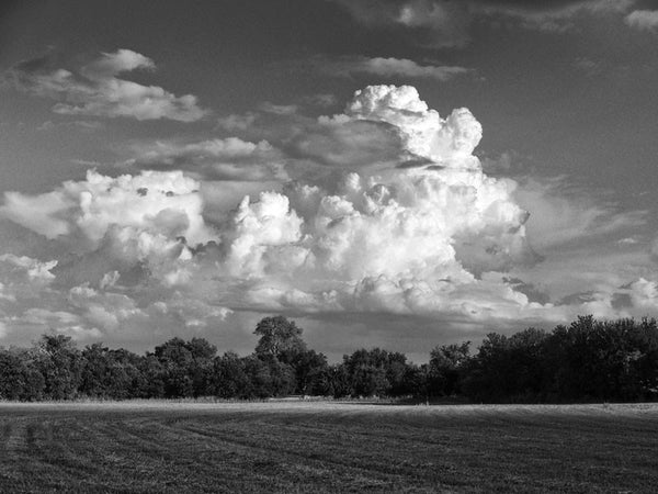 Black and white landscape photograph of brewing storm clouds rising over a farmer's field, near Georgetown, Texas.