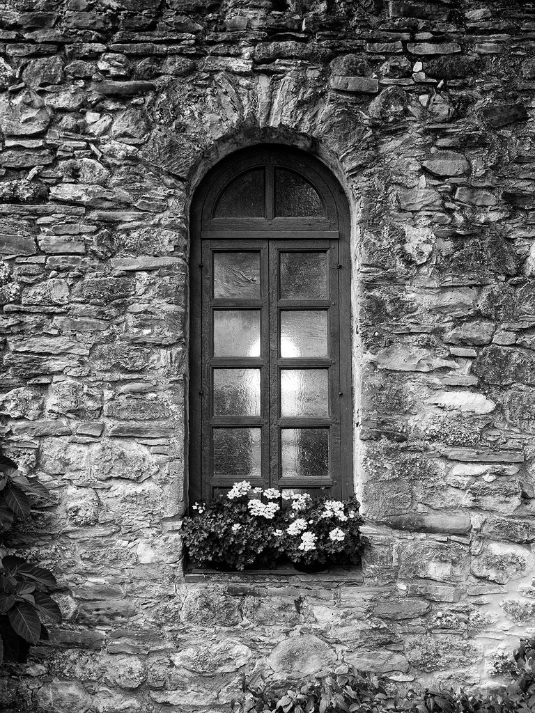 Black and white architectural photograph of the chapel window of an old Spanish mission, built in the 1500s, in San Antonio, Texas.