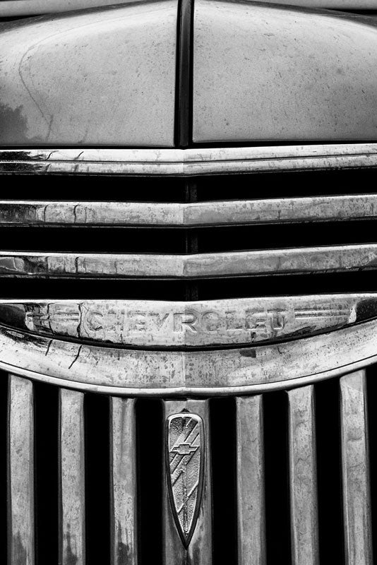 Black and white fine art photograph detail of the hood and chrome grill of a vintage 1947 Chevrolet.