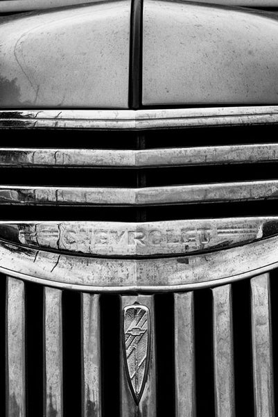 Black and white fine art photograph detail of the hood and chrome grill of a vintage 1947 Chevrolet.