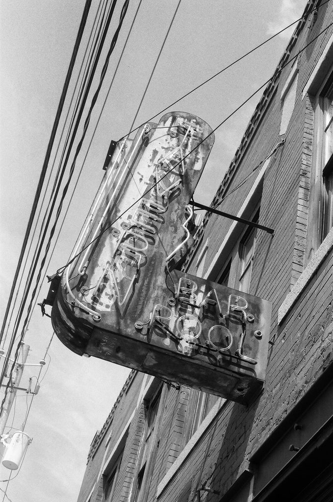 Black and white photograph of rusty and fading neon sign for a bar in the Sweet Auburn neighborhood of Atlanta, Georgia.