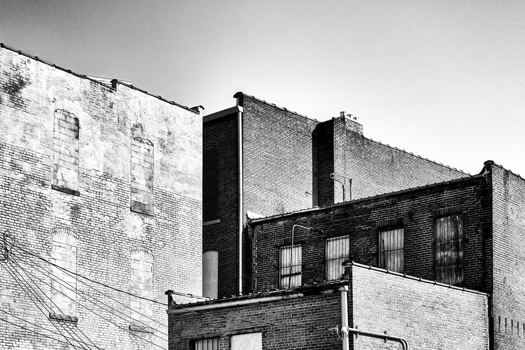 Black and white photograph of old brick buildings in a small town shot in bright afternoon sun. Hopkinsville Kentucky.