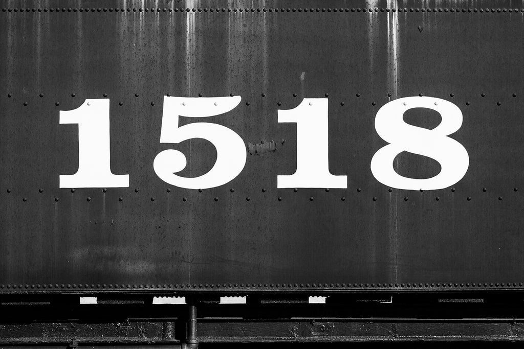 Black and white photograph of the side of an old railroad car displaying the large numbers 1518.