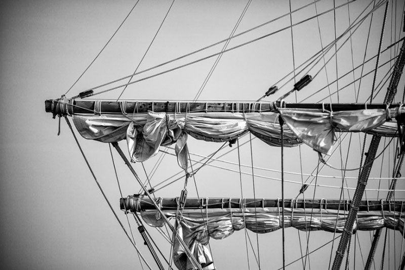 Black and white detail photograph of the rigging of the ropes and sails of an old sailing ship in St. Augustine, Florida.