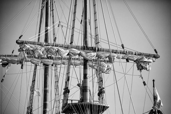 Black and white detail photograph of the masts, rigging, ropes, and sails of a tall sailing ship in St. Augustine, Florida.