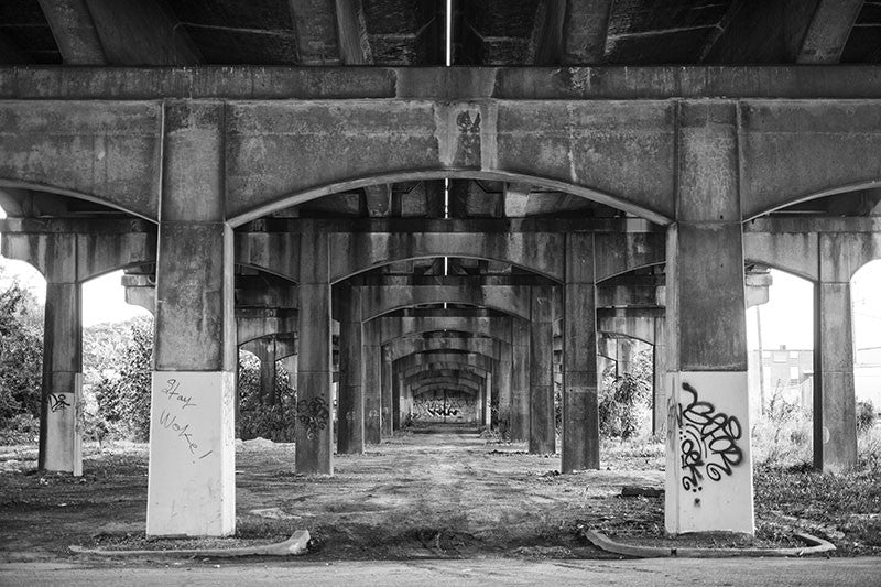 Black and white photograph under the 1st Avenue North bridge that parallels Sloss Furnaces near downtown Birmingham, Alabama.