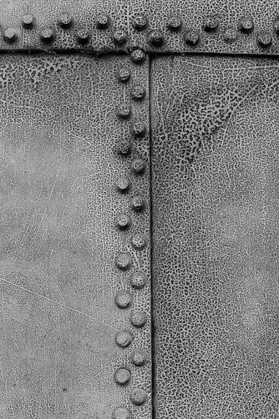 Black and white photograph of cracked paint and rivets on pipes at Sloss Furnaces in Birmingham.
