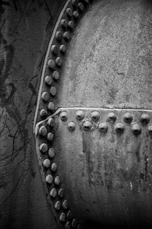 Black and white architectural abstraction photograph of two large pipes connected with rows of rivets at Birmingham's historic Sloss Furnaces.