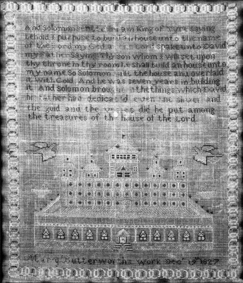 Black and white photograph of a hand-stitched sampler completed in 1827 by Mary Butterworth, seen in Birmingham's historic Arlington House. The sampler features a Bible verse at top, and the bottom reads, "Mary Butterworth's work Dec. 19th, 1827."