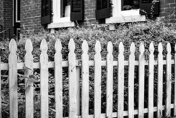 Black and white photograph of a white picket fence in the historic district of St. Charles, Missouri.