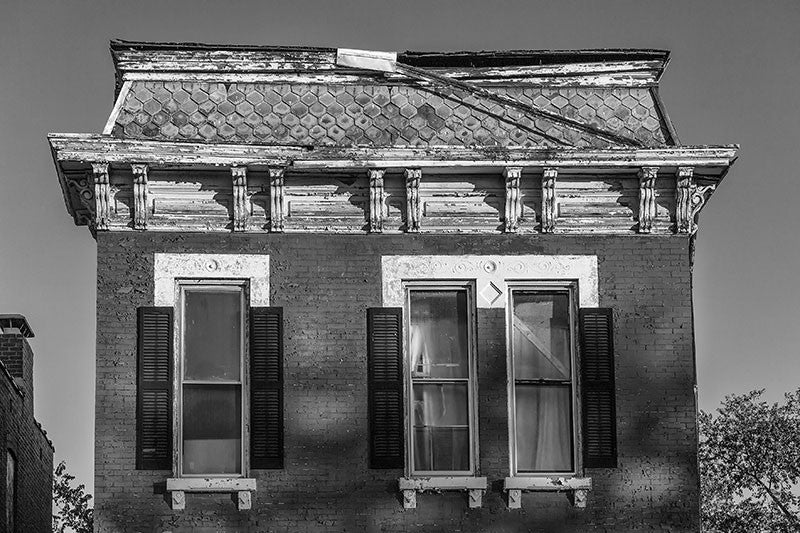 Black and white photograph of a beautiful abandoned historic home in the rough College Hill neighborhood of St. Louis.