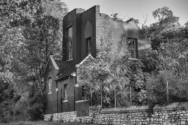 Black and white photograph of an abandoned, collapsing church on an overgrown lot in the College Hill neighborhood of St. Louis.