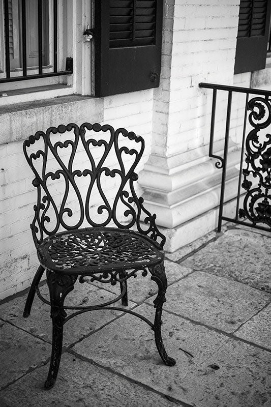Black and white photograph of a chair on the front porch of the beautiful and historic Chantillon-DeMenil Mansion in St. Louis, Missouri.