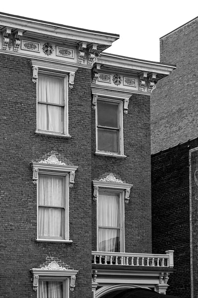 Black and white photograph of ornate wooden window ornaments and brick walls on historic buildings in Nashville, Tennessee.