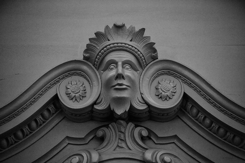 Black and white photograph of a carved wooden face on the interior woodwork of Independence Hall in Philadelphia.