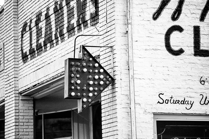 Black and white architectural detail photograph of a red arrow sign on a dry cleaning business in Birmingham, Alabama.