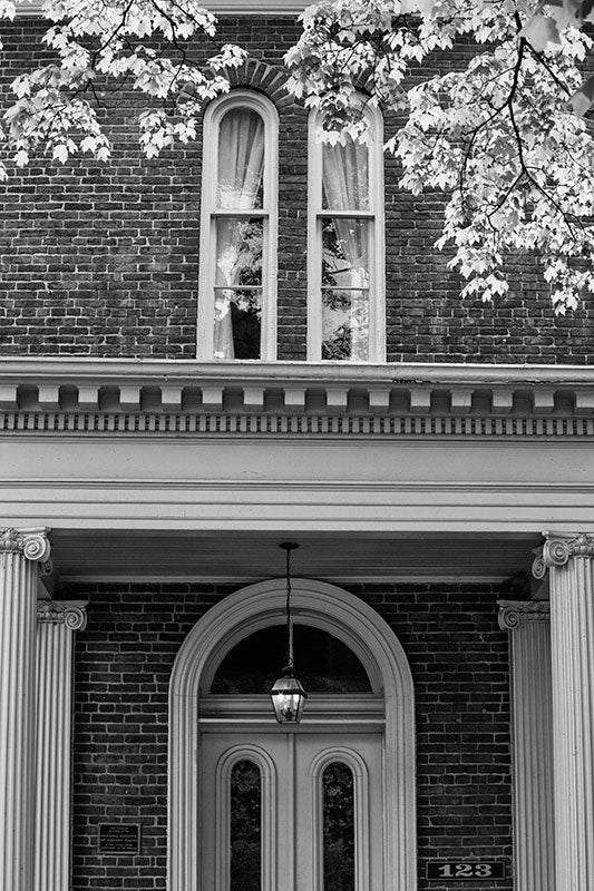 Black and white photograph of the front of a historic Greek Revival house with Ionic columns in Franklin, Tennessee.