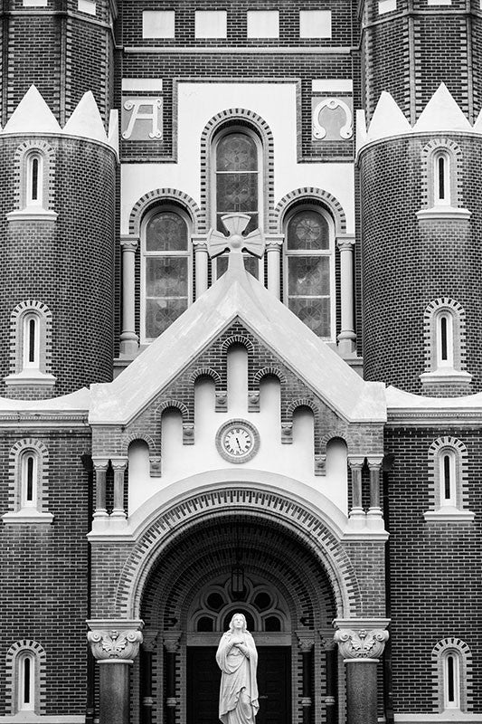 Black and white architectural photograph of the front elevation of the historic Cathedral of St. John the Evangelist in Lafayette, Louisiana. Built in 1918, this is the third church on the property since 1821.