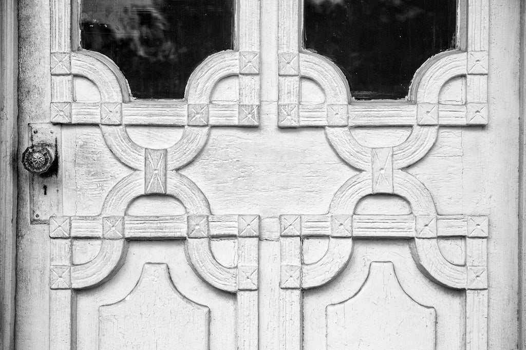 Black and white photograph of the ornate design details on the front door of an old house in Lafayette, Louisiana.