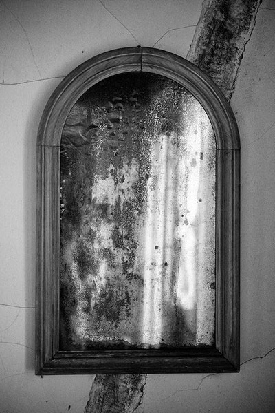 Black and white photograph of a tarnished antique mirror found in an old house in Lafayette, Louisiana.